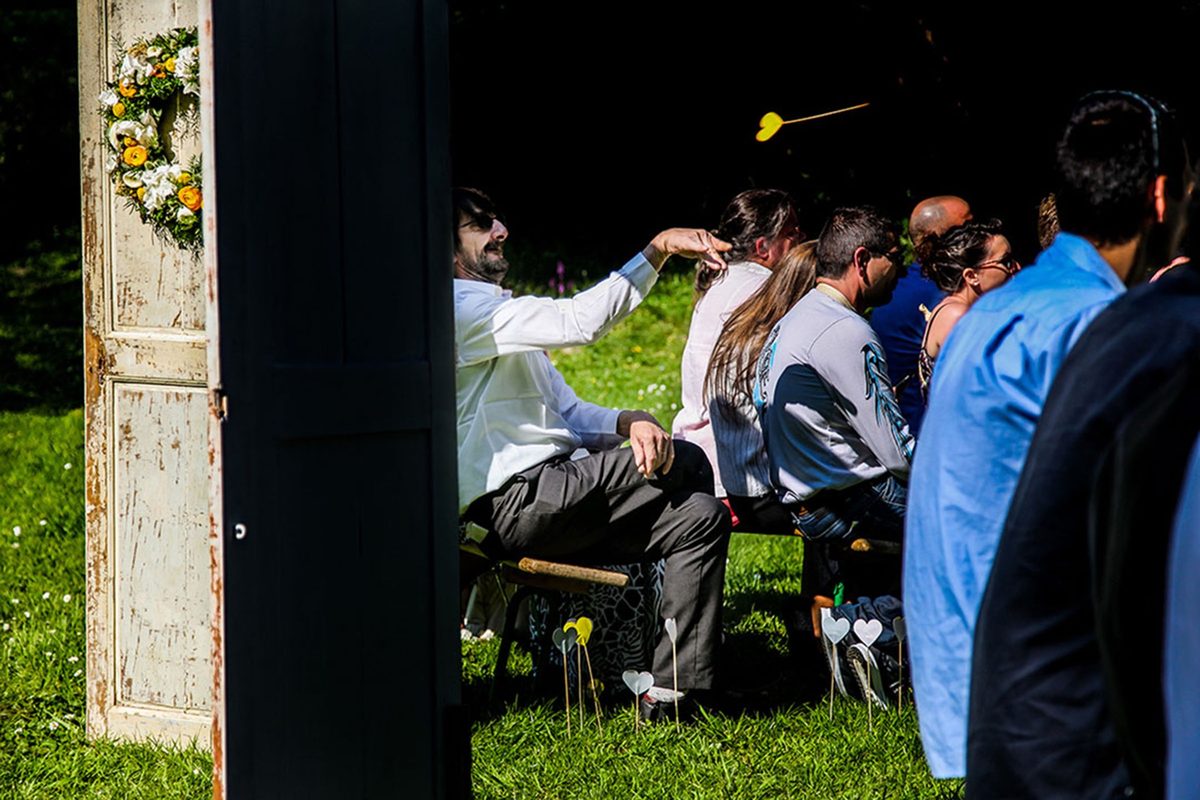 Photographe mariage Calvados — invités cérémonie porte fleurie — Arnaud Chapelle