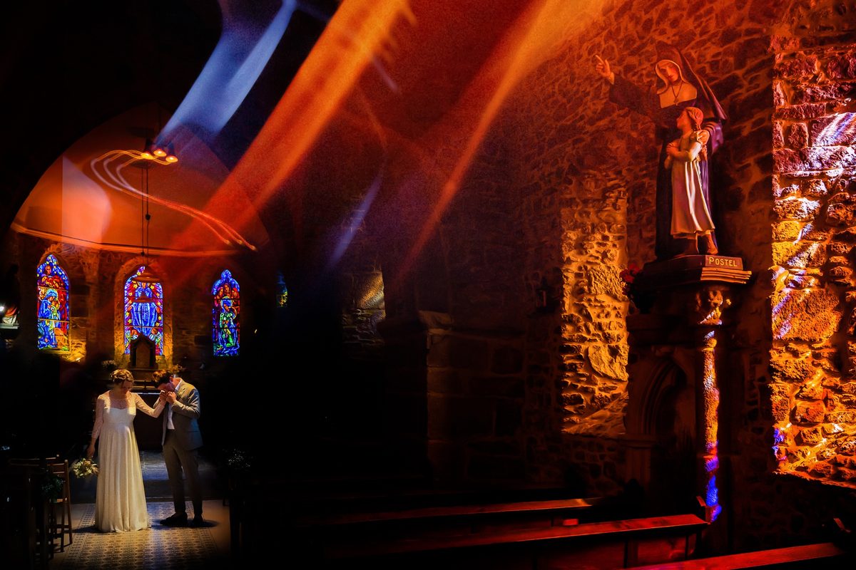 Photographe mariage Normandie — couple église vitraux lumière rouge Manche — Arnaud Chapelle
