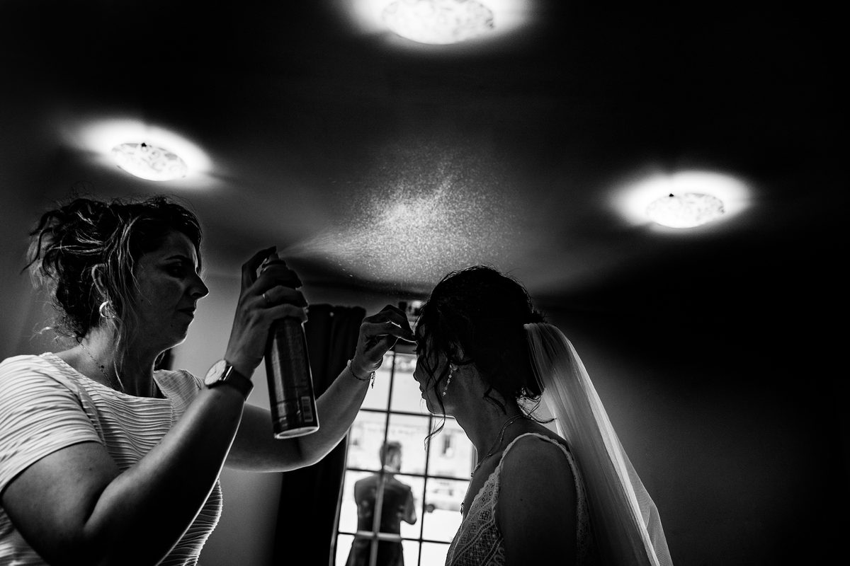 Photographe mariage Calvados — préparatifs coiffure mariée contre-jour — Arnaud Chapelle