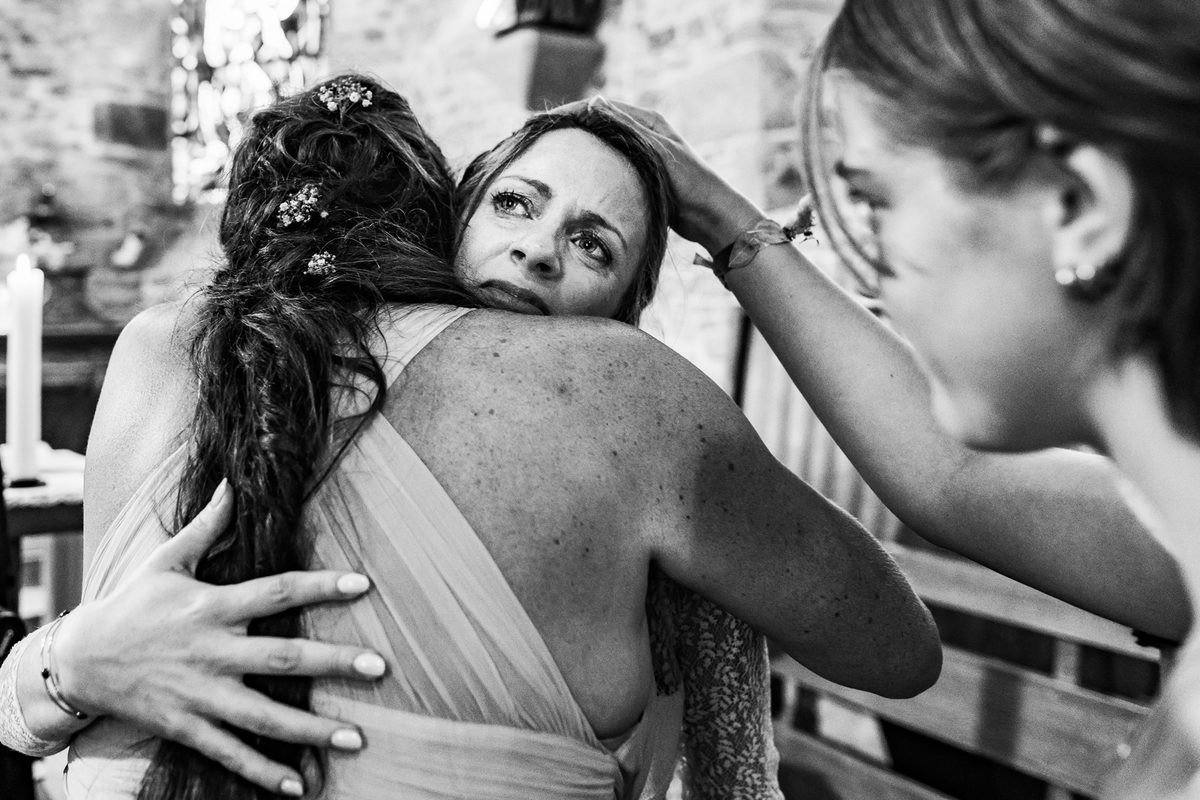 Photographe mariage Normandie — étreinte église émotion larmes — Arnaud Chapelle